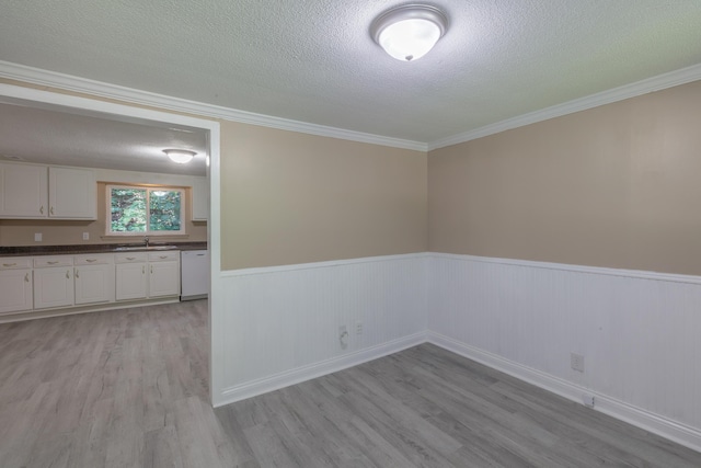 1806 Dallas Lake Rd, Soddy Daisy, TN 37379 - spare room featuring a sink, a textured ceiling, wainscoting, light wood-style flooring, and crown molding
