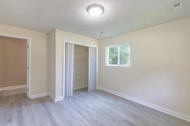 1806 Dallas Lake Rd, Soddy Daisy, TN 37379 - unfurnished bedroom featuring light wood finished floors, a closet, a textured ceiling, and baseboards