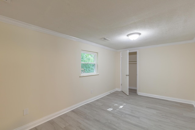 1806 Dallas Lake Rd, Soddy Daisy, TN 37379 - unfurnished bedroom featuring light wood finished floors, baseboards, ornamental molding, a textured ceiling, and a closet