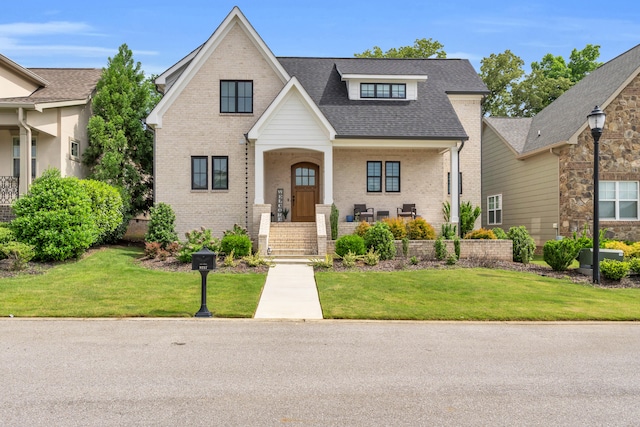 9257 Skyfall Dr, Ooltewah, TN 37363 - view of front of property with brick siding, a front yard, roof with shingles, and a porch