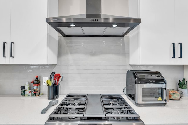 9257 Skyfall Dr, Ooltewah, TN 37363 - kitchen featuring wall chimney exhaust hood, stove, backsplash, and white cabinetry