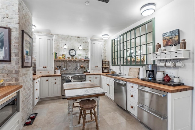 1000 E Martin Luther King Blvd Unit 102, Chattanooga, TN 37403 - kitchen featuring butcher block counters, stainless steel appliances, open shelves, and white cabinets