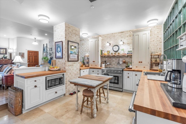 1000 E Martin Luther King Blvd Unit 102, Chattanooga, TN 37403 - kitchen featuring wood counters, stainless steel appliances, open shelves, tasteful backsplash, and light tile patterned floors