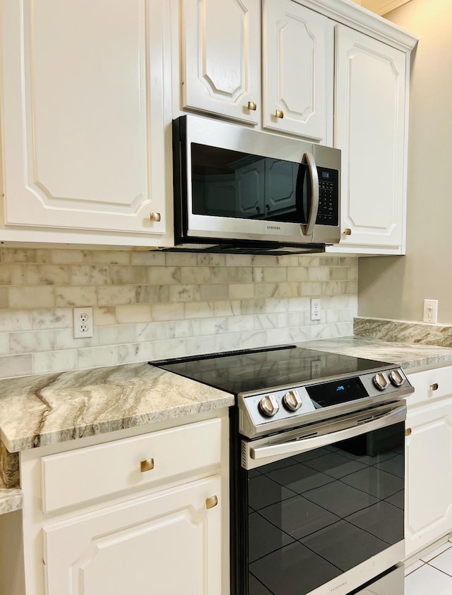 81 Arnold Rd, Rock Spring, GA 30739 - kitchen featuring appliances with stainless steel finishes, white cabinets, tasteful backsplash, and light stone countertops