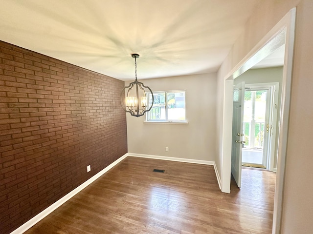 361 Gracie Ave, Ringgold, GA 30736 - unfurnished dining area with brick wall, a chandelier, and wood finished floors