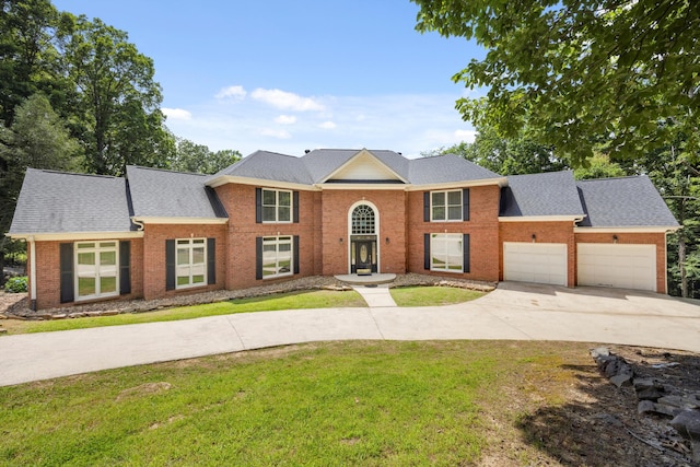 310 Bluffs Rd N, South Pittsburg, TN 37380 - view of front of house featuring concrete driveway, a front yard, brick siding, an attached garage, and roof with shingles