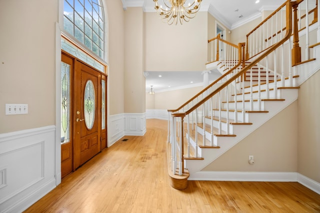 310 Bluffs Rd N, South Pittsburg, TN 37380 - entryway featuring crown molding, stairs, a chandelier, wood finished floors, and a high ceiling