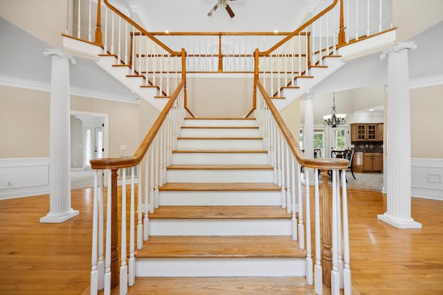 310 Bluffs Rd N, South Pittsburg, TN 37380 - staircase featuring wood finished floors, a towering ceiling, crown molding, decorative columns, and a decorative wall