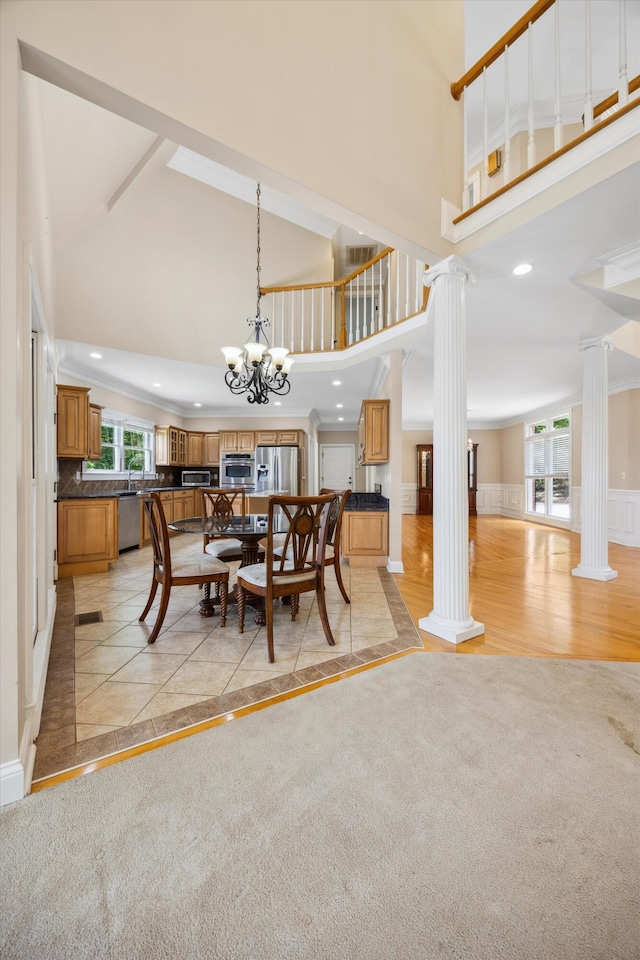 310 Bluffs Rd N, South Pittsburg, TN 37380 - dining area featuring decorative columns, high vaulted ceiling, a chandelier, recessed lighting, and inlaid floor details