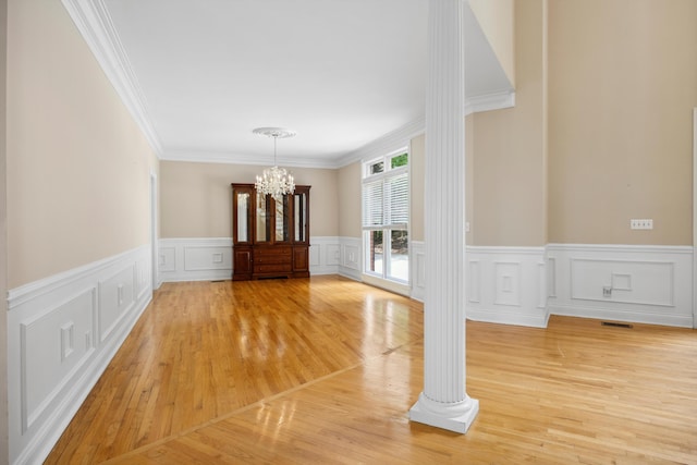 310 Bluffs Rd N, South Pittsburg, TN 37380 - unfurnished dining area featuring a chandelier, light wood-style flooring, crown molding, a wainscoted wall, and a decorative wall