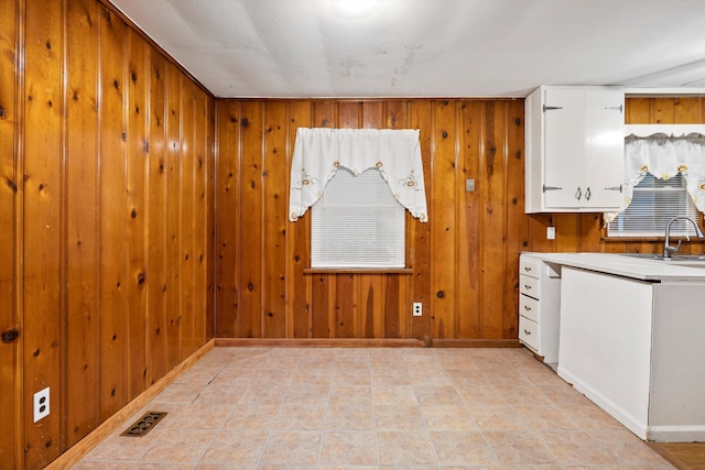 2524 Spring Place Rd SE, Cleveland, TN 37323 - kitchen featuring a sink, white cabinets, baseboards, wood walls, and light countertops
