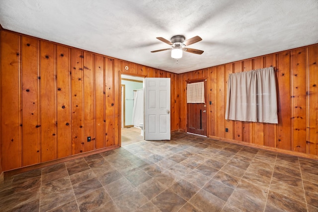 2524 Spring Place Rd SE, Cleveland, TN 37323 - unfurnished room featuring a ceiling fan, wood walls, baseboards, and a textured ceiling