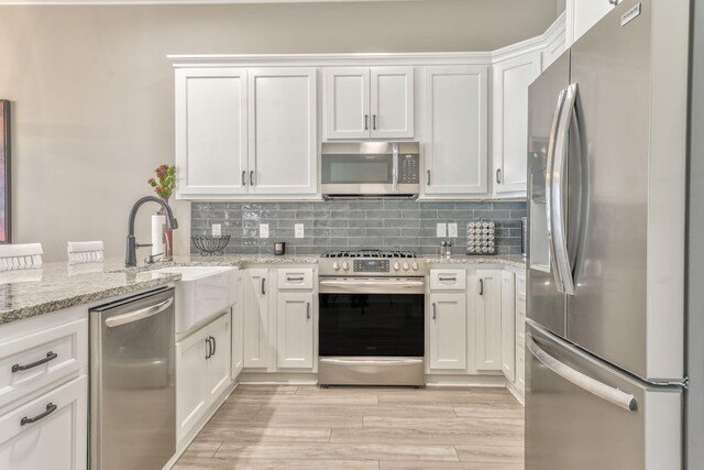 329 Kempton Ln, Dalton, GA 30721 - kitchen featuring appliances with stainless steel finishes, a sink, white cabinetry, and decorative backsplash