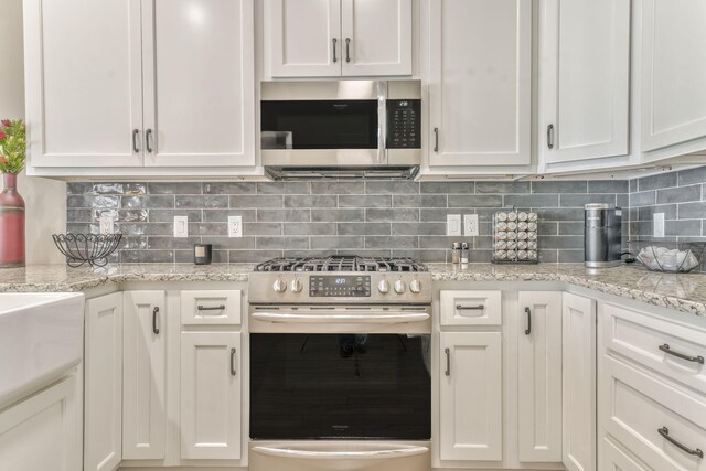 329 Kempton Ln, Dalton, GA 30721 - kitchen with stainless steel appliances, white cabinetry, backsplash, and light stone countertops