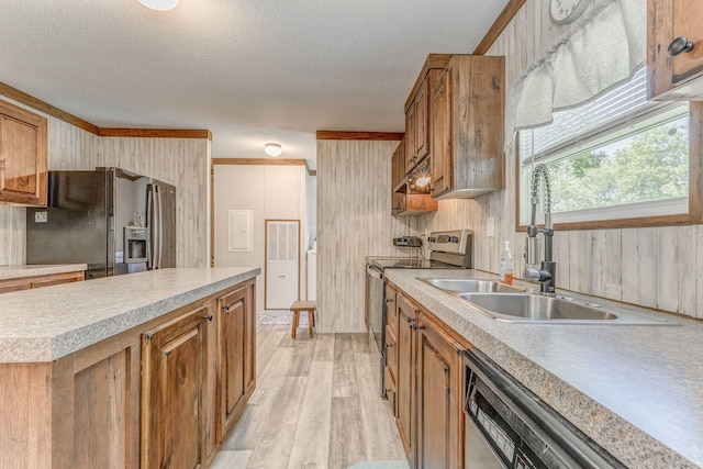 1005 Cohutta Beaverdale Rd, Cohutta, GA 30710 - kitchen featuring appliances with stainless steel finishes, a sink, light wood finished floors, brown cabinetry, and wooden walls