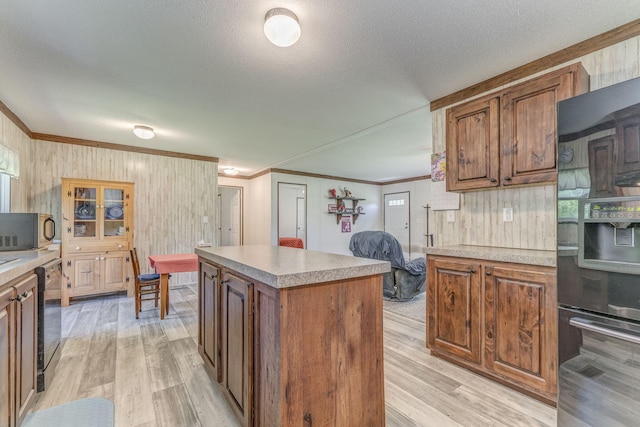 1005 Cohutta Beaverdale Rd, Cohutta, GA 30710 - kitchen with fridge, crown molding, light wood-type flooring, stainless steel microwave, and wooden walls