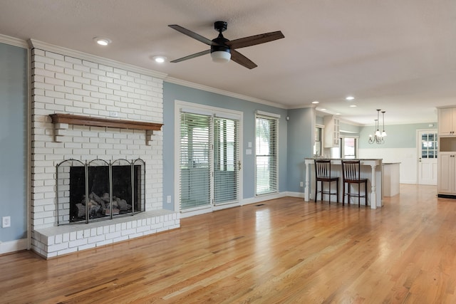2195 Ooltewah Ringgold Rd, Ooltewah, TN 37363 - unfurnished living room featuring a ceiling fan, ornamental molding, a chandelier, light wood-style flooring, and a brick fireplace