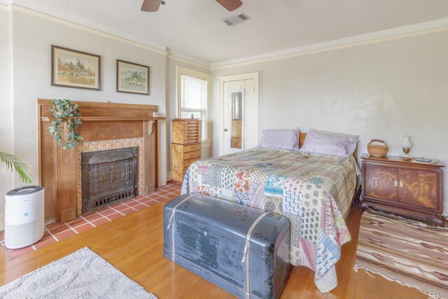 3909 Sunset Ave, Chattanooga, TN 37411 - bedroom with wood finished floors, a tiled fireplace, ornamental molding, and ceiling fan