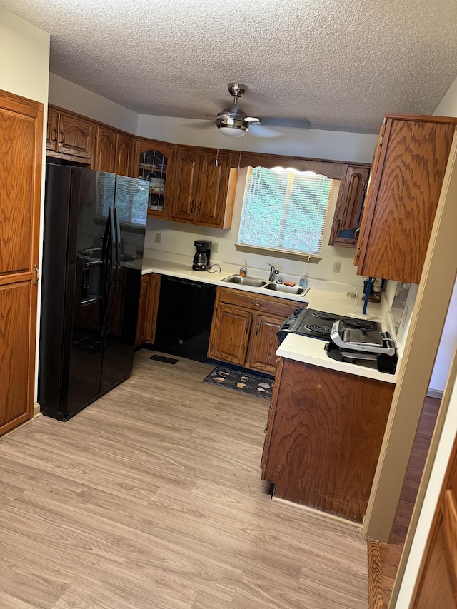 11640 Hixson Pike, Soddy Daisy, TN 37379 - kitchen featuring black fridge, light wood-style flooring, a sink, a ceiling fan, and brown cabinetry