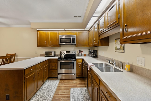 6755 Hickory Creek Rd, Chattanooga, TN 37421 - kitchen with appliances with stainless steel finishes, a sink, light wood finished floors, a peninsula, and light countertops