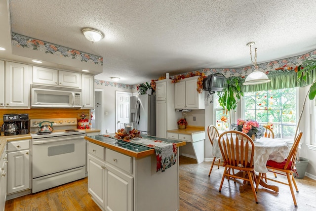 1820 Colonial Way Cir, Hixson, TN 37343 - kitchen featuring white appliances, a textured ceiling, white cabinetry, light wood-style flooring, and a center island