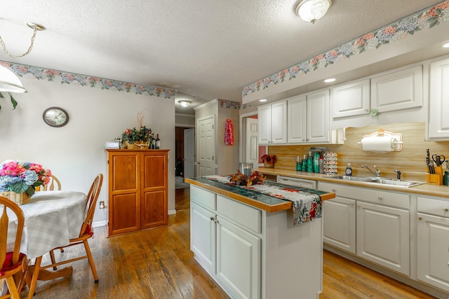 1820 Colonial Way Cir, Hixson, TN 37343 - kitchen featuring a sink, a textured ceiling, white cabinetry, a center island, and light wood finished floors