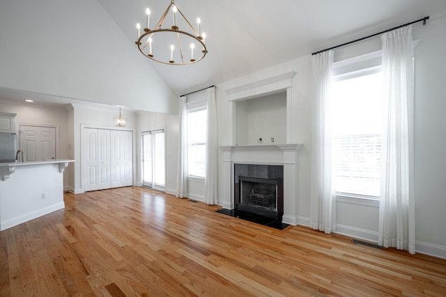 8539 Lexie Ln, Ooltewah, TN 37363 - unfurnished living room featuring high vaulted ceiling, a chandelier, light wood finished floors, and a fireplace