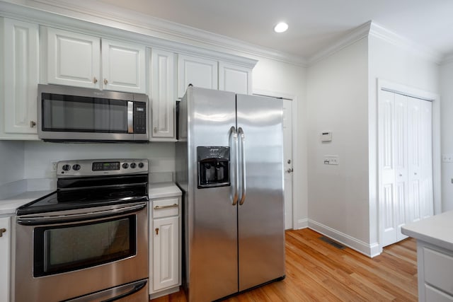 8539 Lexie Ln, Ooltewah, TN 37363 - kitchen with stainless steel appliances, light countertops, crown molding, light wood-type flooring, and white cabinetry