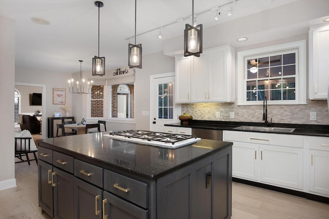 3 Chamblee Ct, Signal Mountain, TN 37377 - kitchen featuring white gas cooktop, white cabinets, backsplash, and a chandelier