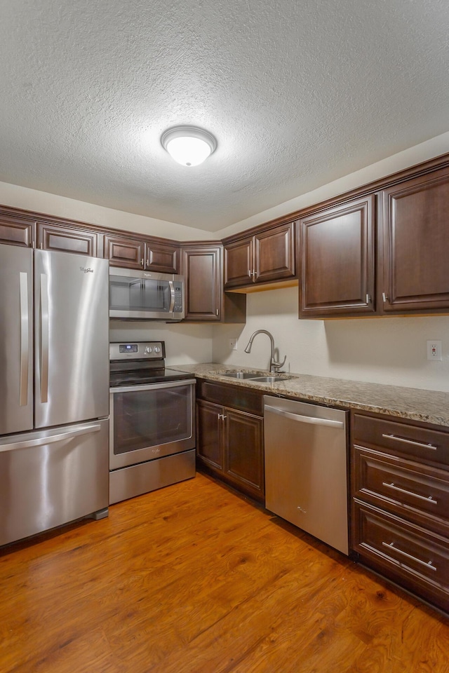 900 Mountain Creek Rd Unit Q263, Chattanooga, TN 37405 - kitchen featuring stainless steel appliances, dark brown cabinets, a textured ceiling, wood finished floors, and light stone counters