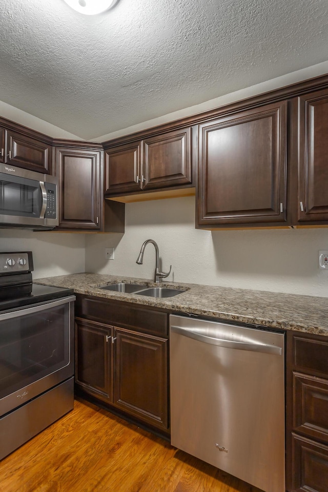 900 Mountain Creek Rd Unit Q263, Chattanooga, TN 37405 - kitchen with stainless steel appliances, dark brown cabinetry, light wood finished floors, and a textured ceiling