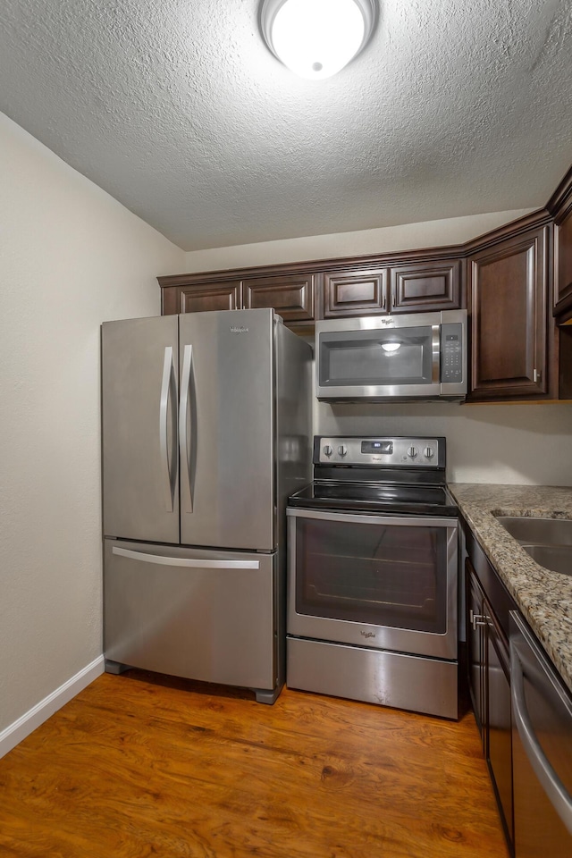 900 Mountain Creek Rd Unit Q263, Chattanooga, TN 37405 - kitchen with stainless steel appliances, dark brown cabinets, wood finished floors, a textured ceiling, and stone countertops