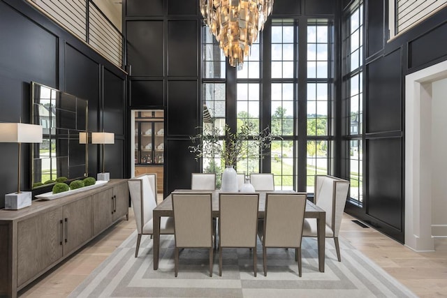 3634 Falkirk Way, Ooltewah, TN 37363 - dining area with a high ceiling, a chandelier, light wood-style flooring, and a decorative wall