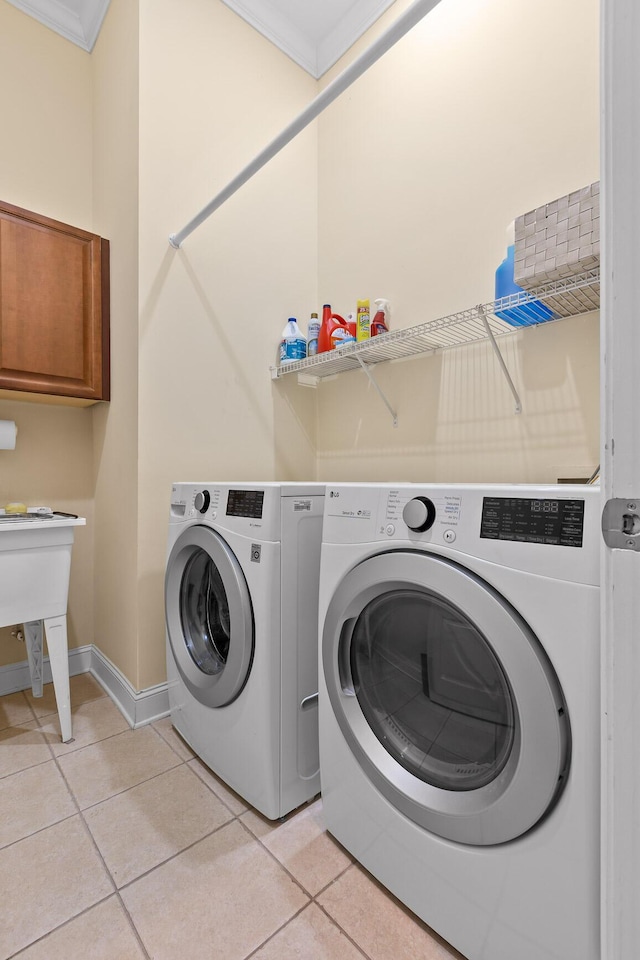 1008 Renaissance Ct, Chattanooga, TN 37419 - laundry area with washing machine and clothes dryer, light tile patterned floors, cabinet space, and crown molding