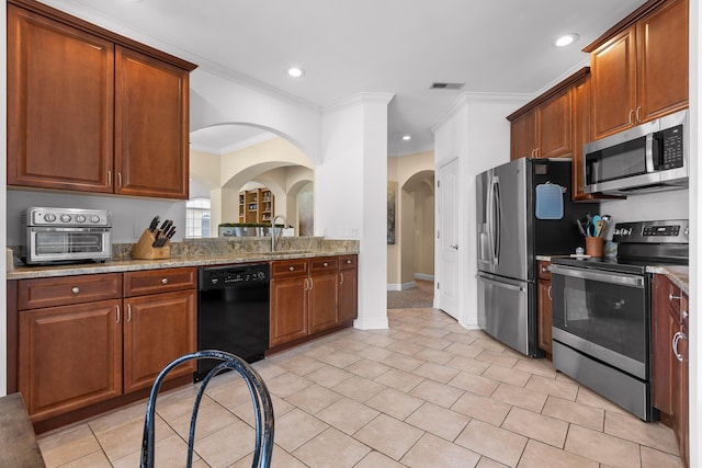 1008 Renaissance Ct, Chattanooga, TN 37419 - kitchen featuring appliances with stainless steel finishes, crown molding, recessed lighting, light stone counters, and brown cabinets