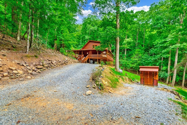 879 Amy Creek Cir, Ellijay, GA 30540 - rustic home featuring a storage unit, stairway, log veneer siding, a wooden deck, and a wooded view