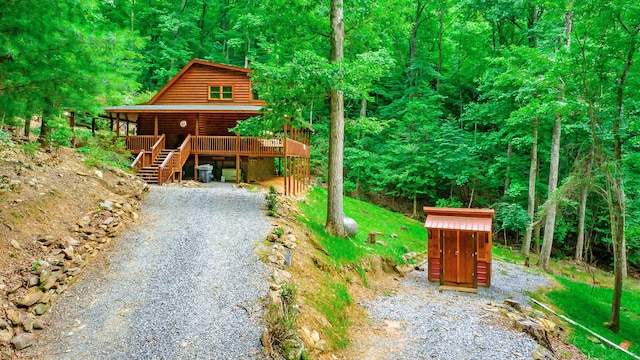 879 Amy Creek Cir, Ellijay, GA 30540 - view of front facade with log veneer siding, a forest view, stairway, and a shed