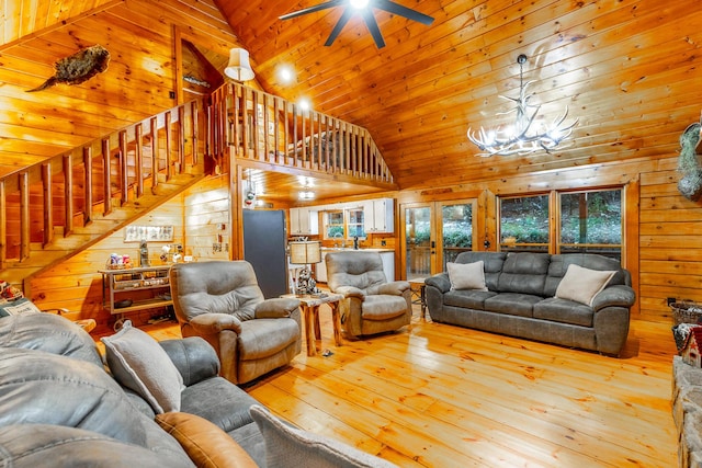 879 Amy Creek Cir, Ellijay, GA 30540 - living room featuring hardwood / wood-style floors, wood walls, stairway, a ceiling fan, and a chandelier