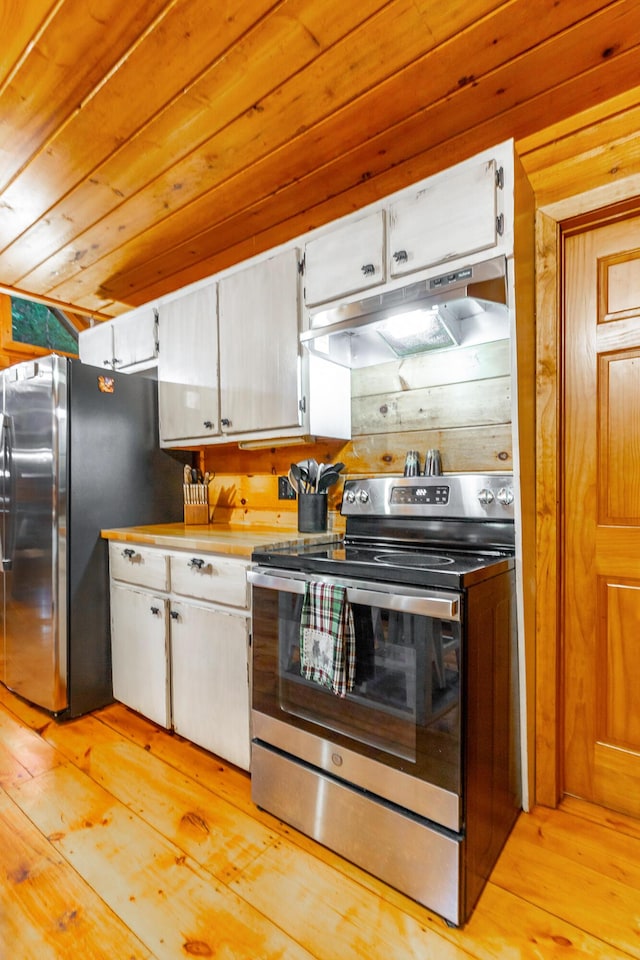 879 Amy Creek Cir, Ellijay, GA 30540 - kitchen with stainless steel appliances, light wood finished floors, under cabinet range hood, white cabinetry, and wooden walls