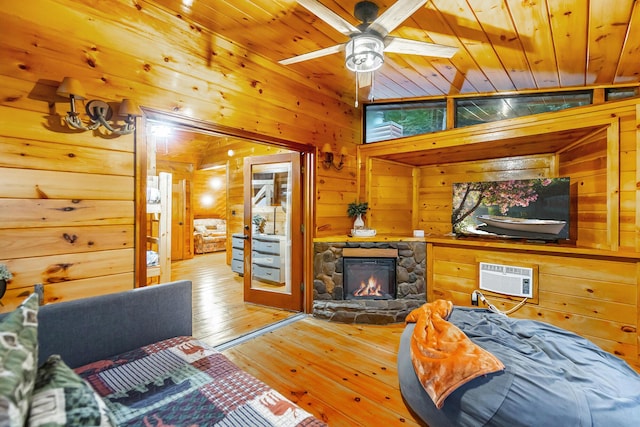 879 Amy Creek Cir, Ellijay, GA 30540 - living room featuring wood walls, hardwood / wood-style floors, a wall unit AC, a fireplace, and a ceiling fan