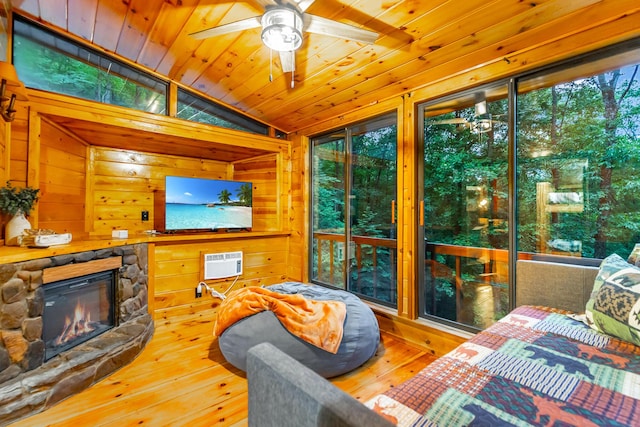 879 Amy Creek Cir, Ellijay, GA 30540 - living room featuring vaulted ceiling, ceiling fan, wood-type flooring, a wall unit AC, and a stone fireplace