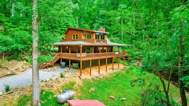 879 Amy Creek Cir, Ellijay, GA 30540 - back of house with a chimney, log siding, a deck, stairway, and a view of trees