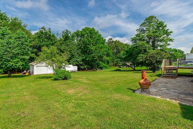 133 Wood Meadow Trl, Ringgold, GA 30736 - view of green lawn with a wooden deck, a detached garage, and an outbuilding