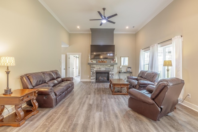 905 Live Oak Rd, Ringgold, GA 30736 - living area featuring a ceiling fan, wood finished floors, a towering ceiling, a stone fireplace, and crown molding