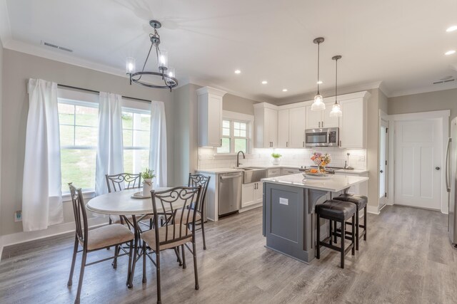 905 Live Oak Rd, Ringgold, GA 30736 - kitchen with stainless steel appliances, backsplash, white cabinetry, light countertops, and a kitchen island