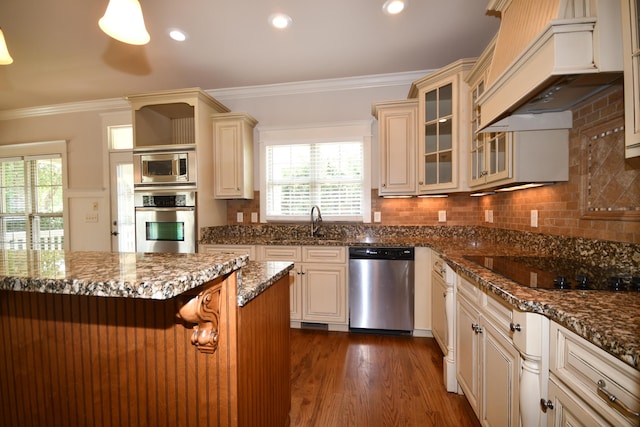 9532 Wandering Way, Ooltewah, TN 37363 - kitchen with appliances with stainless steel finishes, custom exhaust hood, ornamental molding, glass insert cabinets, and dark wood-type flooring