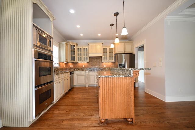 9532 Wandering Way, Ooltewah, TN 37363 - kitchen with stainless steel appliances, crown molding, cream cabinets, a center island, and wood finished floors