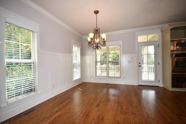 9532 Wandering Way, Ooltewah, TN 37363 - unfurnished dining area featuring a chandelier, a decorative wall, wood finished floors, wainscoting, and crown molding