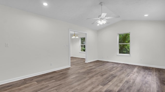 607 Gregory Ln, Lafayette, GA 30728 - empty room with healthy amount of natural light, a ceiling fan, lofted ceiling, dark wood-type flooring, and a chandelier
