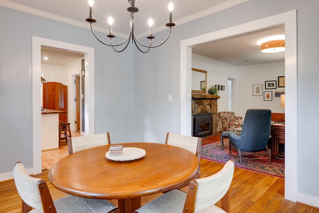 511 Georgia Ave, Signal Mountain, TN 37377 - dining space featuring a fireplace, ornamental molding, light wood-type flooring, and a chandelier